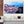 Tableau mural représentant Lisbonne avec ses toits rouges, ses façades blanches et une vue sur le Tage avec bateau à l’horizon