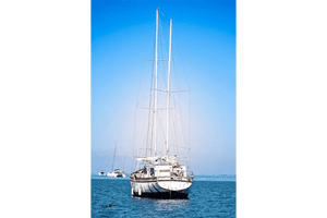Fine art photo of sailboat on calm blue sea with clear sky and textured artistic effect