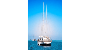 Sailboat anchored on calm blue sea under clear sky, maritime photography print