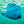 Photographie sous-marine d’une raie nageant dans une eau turquoise éclairée par la lumière