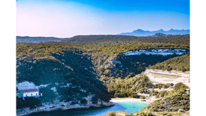 Tableau décoratif d’un paysage naturel avec crique turquoise, collines verdoyantes et montagnes sous un ciel bleu - Plexiglas - ESPOIR PHOTOS