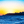 Tableau décoratif représentant un coucher de soleil doré sur la mer avec vagues bleues et silhouette rocheuse à l’horizon - Plexiglas - ESPOIR PHOTOS