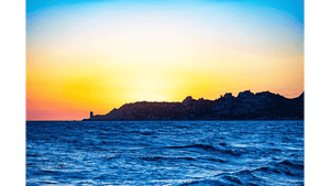Tableau décoratif représentant un coucher de soleil doré sur la mer avec vagues bleues et silhouette rocheuse à l’horizon - Plexiglas - ESPOIR PHOTOS